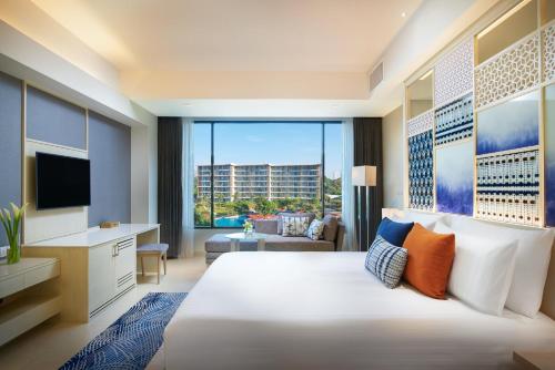 a bedroom with a large white bed and a large window at Amari Pattaya in Pattaya