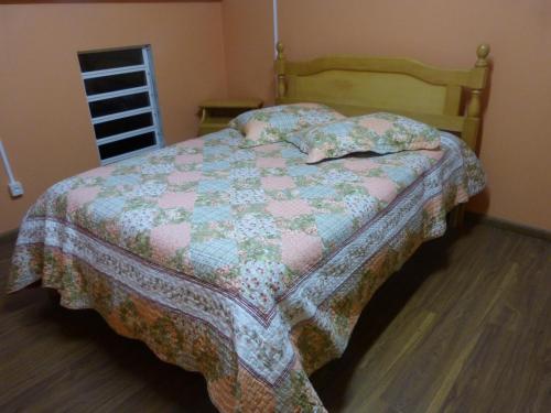 1 dormitorio con 1 cama con edredón en Lago do Bosque, en Gramado