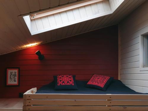 a bedroom with a bed with a red wall and a skylight at Miko II in Slavske