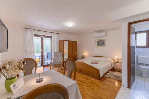 a bedroom with a bed and a bathroom with a tub at Apartments Koraca in Poreč