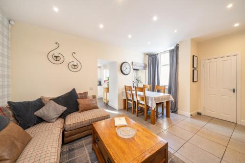 a living room with a couch and a table at Fionas Cottage in Crieff