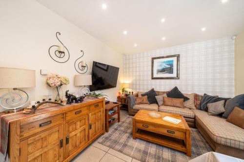 a living room with a couch and a tv at Fionas Cottage in Crieff
