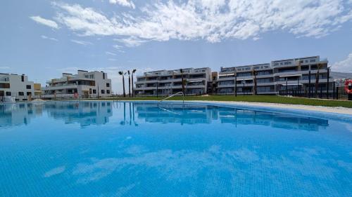 a large swimming pool in front of some apartment buildings at CAMPOROSSO magic apartment in Finestrat