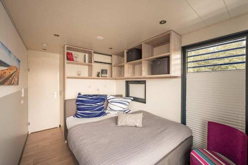 a bedroom with a bed with blue and white pillows at Floatinghouse Nike in Hennigsdorf