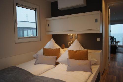 a room with a bed with white sheets and pillows at Floatinghouse Auszeit - LP11 in Vetschau
