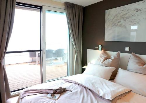 a bedroom with a bed and a large window at Floatinghouse Bernstein Suite in Ribnitz-Damgarten