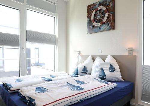 a bedroom with a large bed with blue and white pillows at Floatinghouse Ankerplatz in Ribnitz-Damgarten