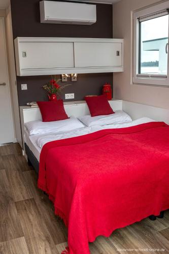 a bedroom with two beds with a red blanket at Floatinghouse KonTiki - LP8 in Vetschau