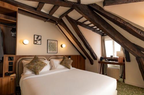 a bedroom with a white bed in a room with beams at Salvia Paris in Paris