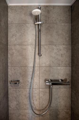 a shower with a shower head in a bathroom at Floatinghouse Red Pearl in Zehdenick