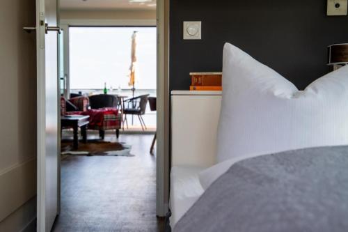 a bedroom with a white bed and a living room at Floatinghouse Queen - LP6 in Vetschau