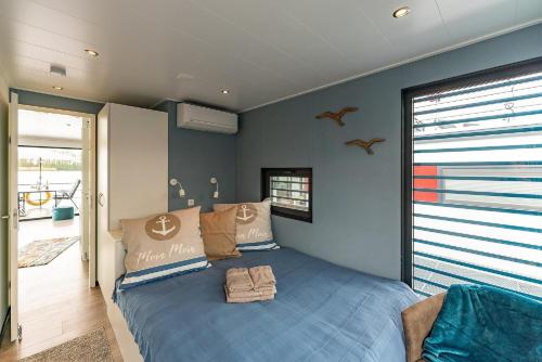 a bedroom with a blue bed in a room at Floatinghouse Topas in Zehdenick
