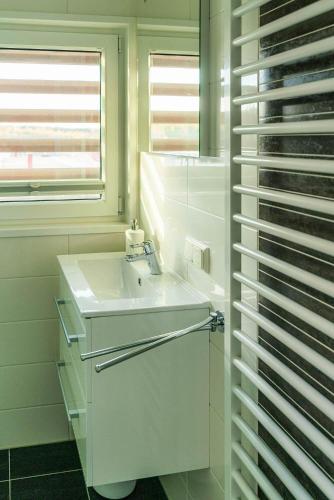 a white bathroom with a sink and a window at Floatinghouse Paradise in Klitten