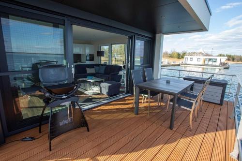 a deck with a table and chairs on a boat at Floatinghouse Dolce Vita - LP10 in Vetschau