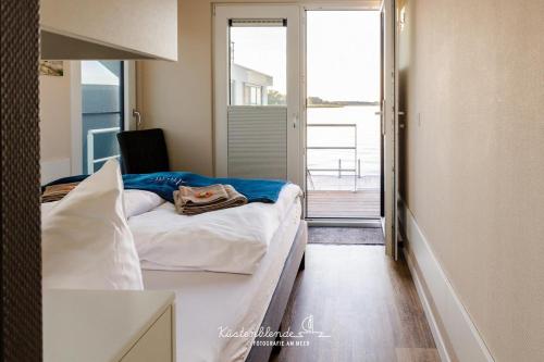a bedroom with a bed and a view of a balcony at Floatinghouse Arielle in Ribnitz-Damgarten