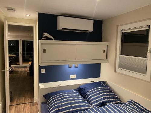 a bedroom with a bed and a tv on the wall at Floatinghouse Seensucht - LP14 in Vetschau