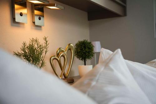 a bed with two gold hearts on the wall at Floatinghouse Neptun - LP3 in Vetschau