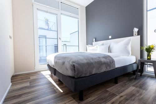 a bedroom with a bed and a large window at Floatinghouse Meerkraft in Ribnitz-Damgarten