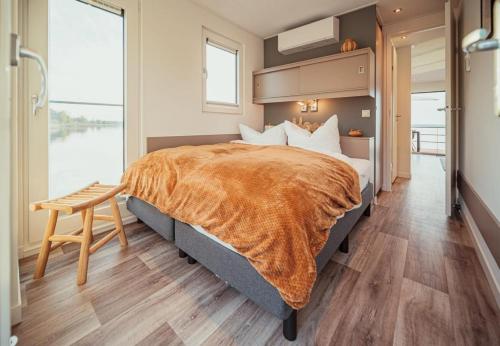 a bedroom with a large bed with an orange blanket at Floatinghouse Cosy Home - LP16 in Vetschau
