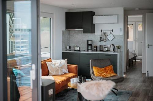 a living room with a couch and a kitchen at Floatinghouse Cosy Home - LP16 in Vetschau