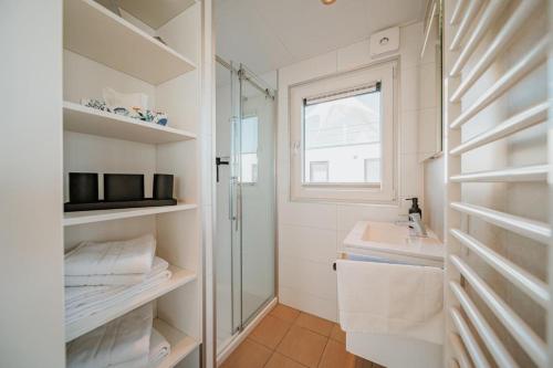 a white bathroom with a shower and a sink at Floatinghouse Seeblick - LP7 in Vetschau