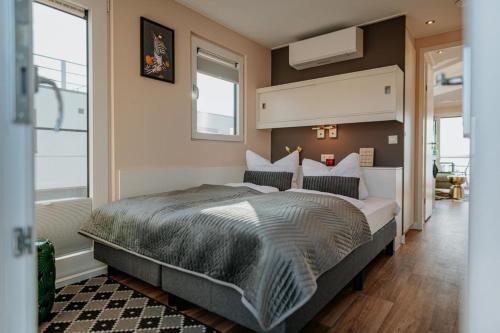 a bedroom with a large bed and two windows at Floatinghouse Seeblick - LP7 in Vetschau