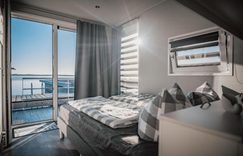 a bedroom with a bed and a view of the ocean at Floatinghouse Möwe 4 - LP4 in Vetschau