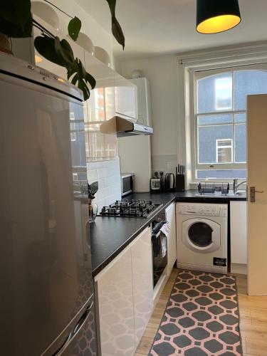a kitchen with a washing machine and a washer and dryer at Central quality point piccadilly in London