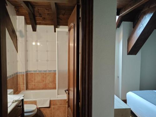 a bathroom with a toilet and a bath tub at Hotel Rural Eseverry-Bosque Irati in Jaurrieta