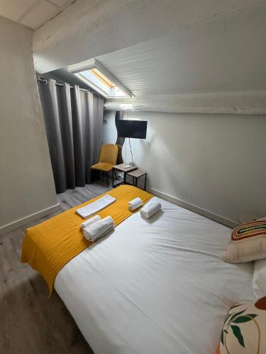 a bedroom with a large white bed with towels on it at Le central in Balaruc-les-Bains