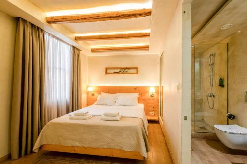 a bedroom with a bed and a tub and a sink at Panellinion Luxury Rooms in Kalamata