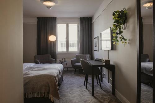 a hotel room with a bed and a table and chairs at Home Hotel Victoria in Jönköping