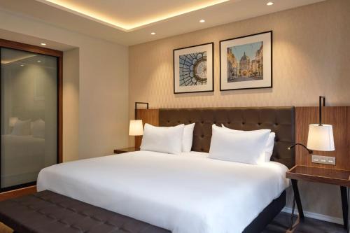 a bedroom with a large white bed and a desk at Eurostars Avenue Louise in Brussels