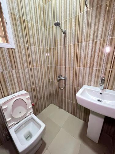 a bathroom with a toilet and a sink at Shana Homes in Karsana