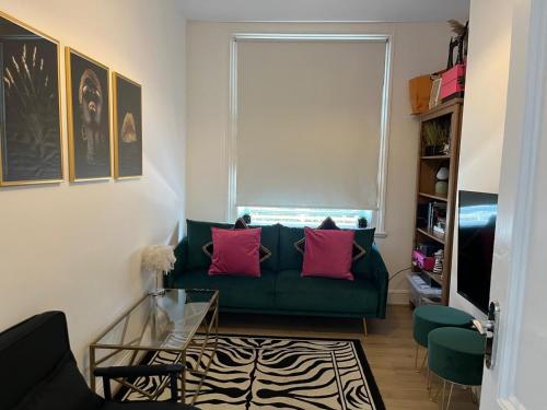 a living room with a green couch and a window at Central quality point piccadilly in London