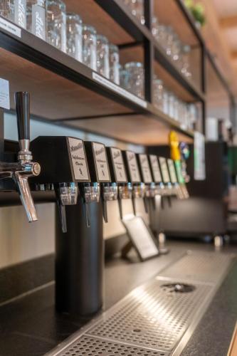 a bar with a row of glasses on a counter at BERGlässig Hotel - Halbpension Plus inkl Getränke in Bodenmais