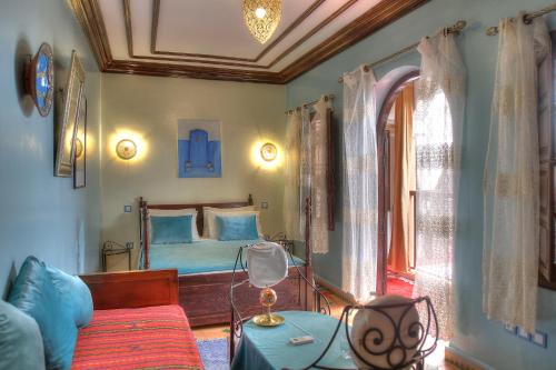 a bedroom with a bed and a table with a lamp at Riad ELIZZI in Marrakesh