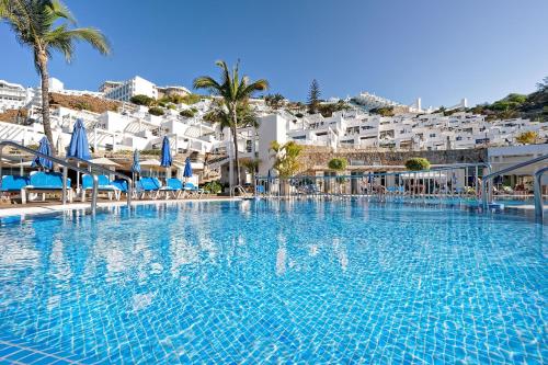 a large swimming pool with blue and white buildings at Bahia Blanca in Puerto Rico de Gran Canaria