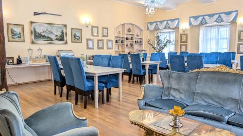 a dining room with blue chairs and tables at Rezydencja Dwór Górny in Nowa Ruda