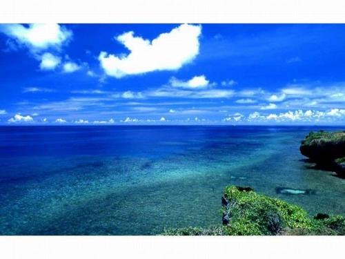 a large body of water with a blue sky and clouds at Pension Iriomote in Iriomote