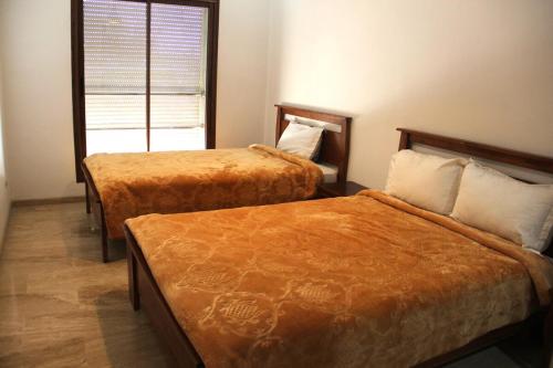 a hotel room with two beds and a window at New Fez Apartments in Fez