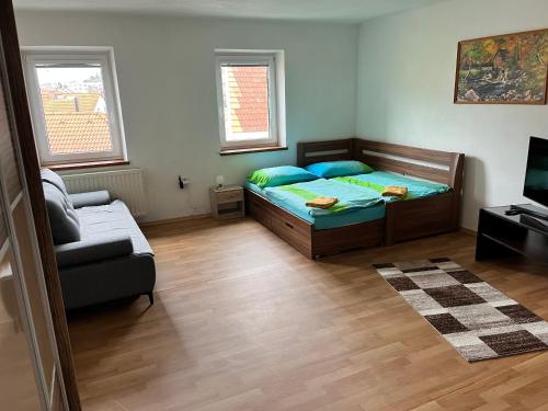 a small bedroom with a bed and a couch at Apartmány RK in Horažďovice