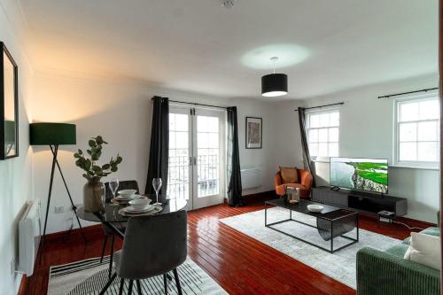 a living room with a table and a tv at Bright 1 Bed Harbour-side Apartment with Balcony in Whitehaven
