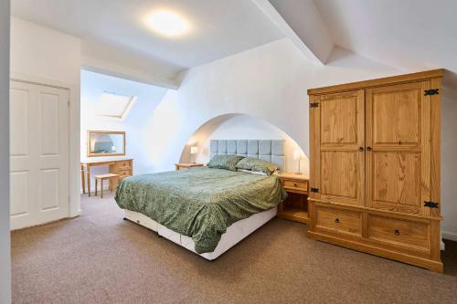 a bedroom with a bed and a wooden cabinet and a desk at Host & Stay - Llanberis Flat in Llanberis
