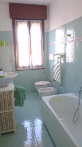 a bathroom with a tub and a toilet and a sink at Appartamento Ca' Lela in Marghera