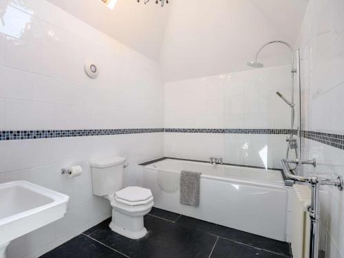 a white bathroom with a toilet and a tub and a sink at 1 Bed in Dorchester oc-dc026 in Broadmayne