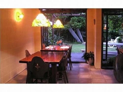 a dining room with a table and chairs and a window at Pension Iriomote in Iriomote