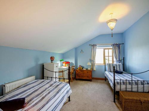 a bedroom with two beds and a window at 3 Bed in Tywyn oc-dy021 in Tywyn