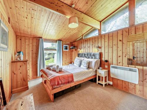 a bedroom with a bed in a room with wooden walls at 2 Bed in Aberdyfi oc-dy050 in Aberdyfi
