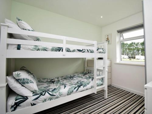 a bedroom with two bunk beds and a window at 2 Bed in Swansea oc-88744 in Knelston